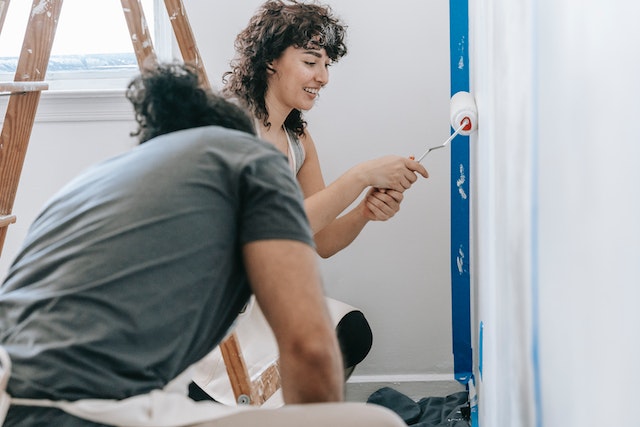 A woman and a man painting the wall