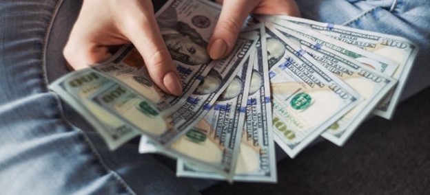 A person holding hundred-dollar bills.