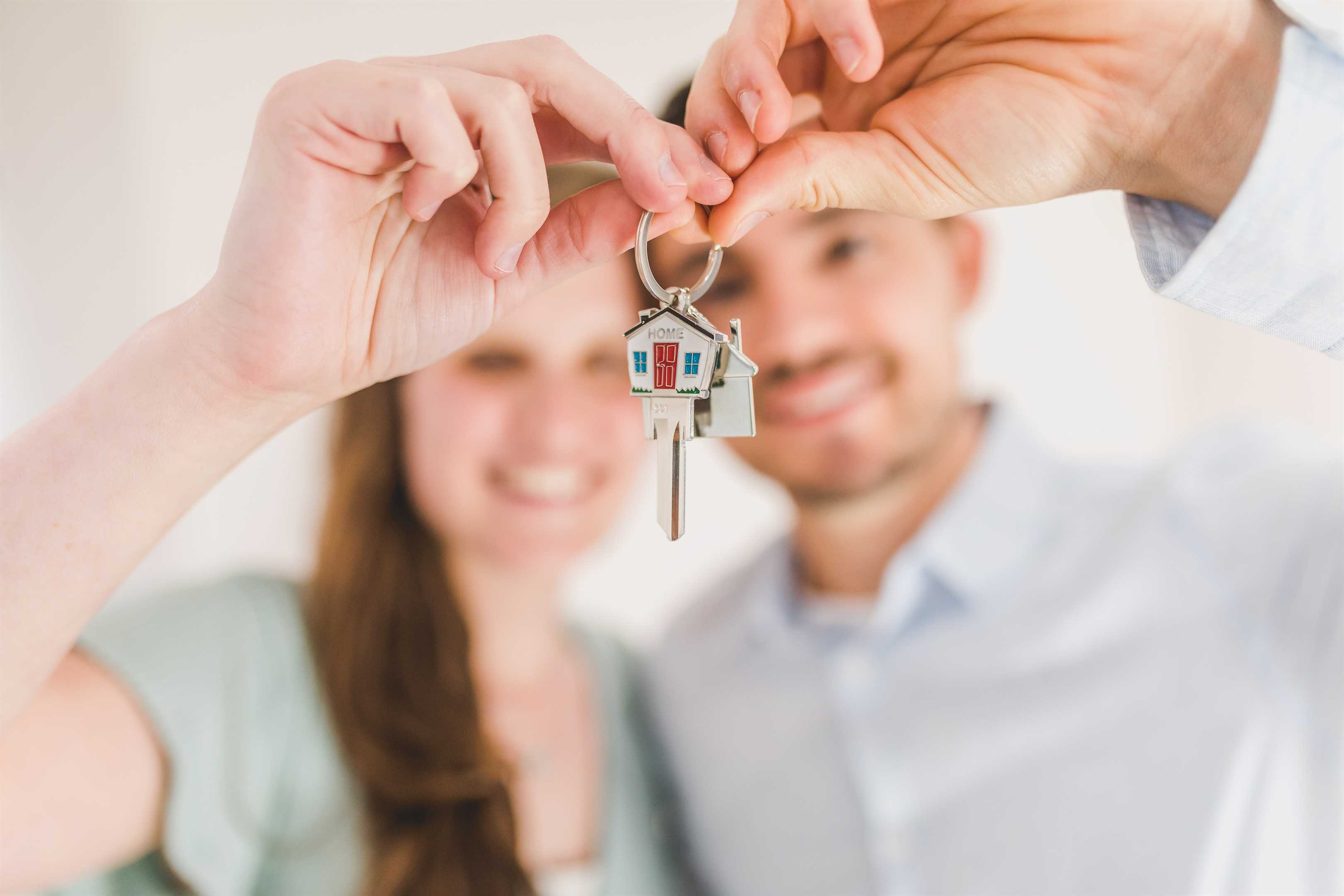 A young couple holding the keys to their new house