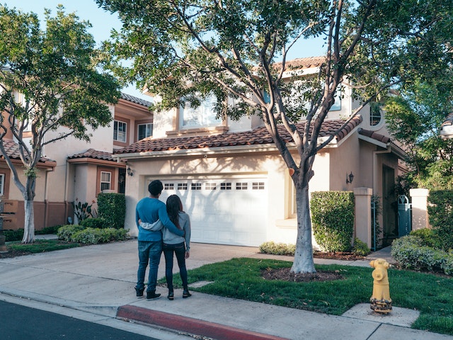 A couple standing in front of a house