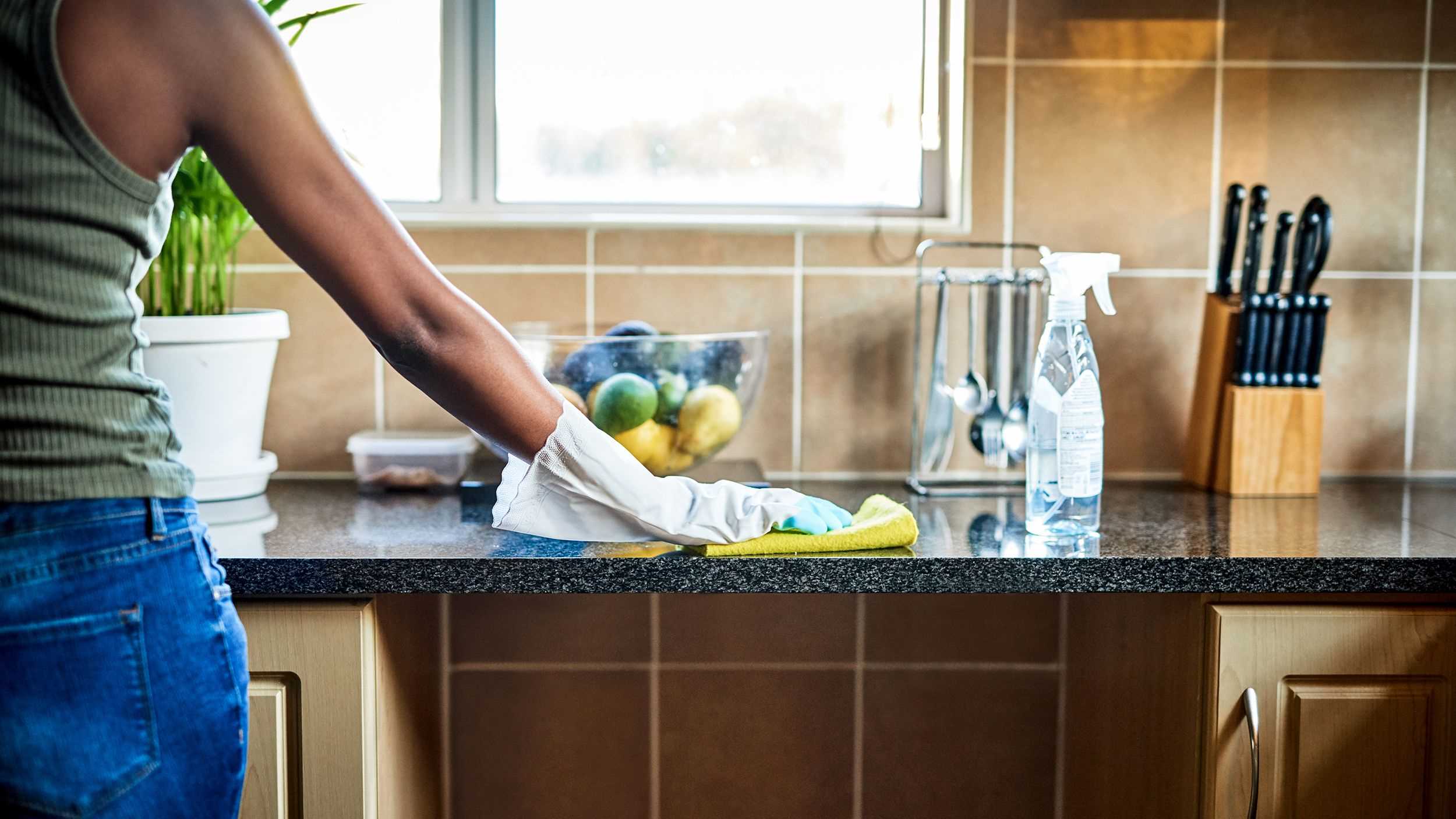 Woman cleaning the kitchen sink with good cleaning product