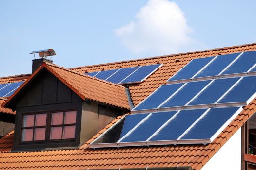 Solar panels on roof of home with windows and shingles.