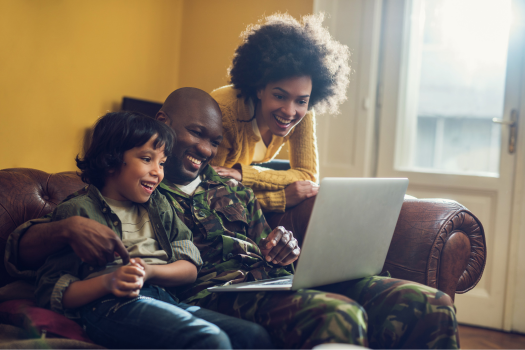 happy_military_family_looking_at_computer_while_on_the_couch