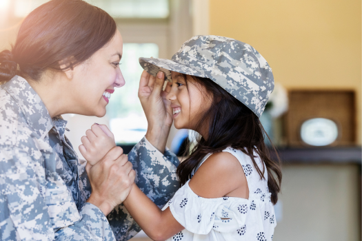 military_child_standing_in_front_of_their_military_parent_while_wearing_their_hat