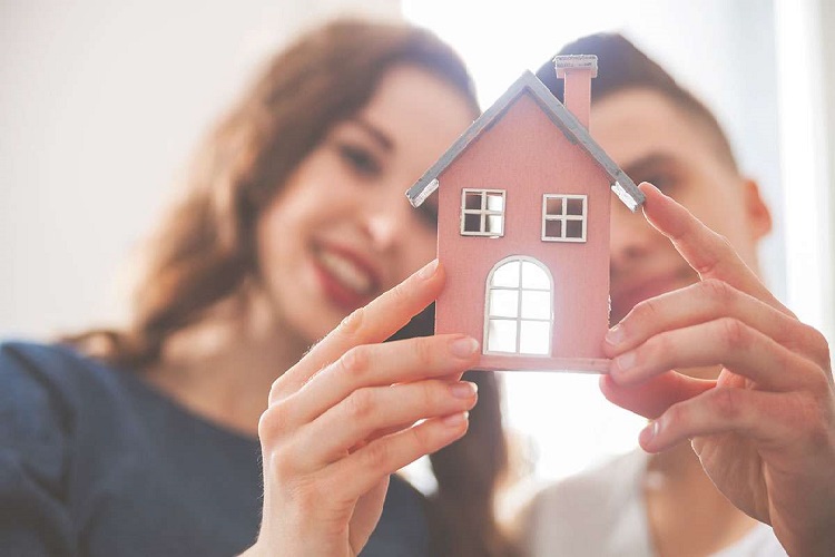Man and Woman holding a small model home