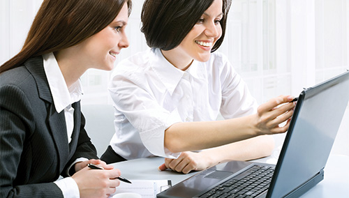 two women looking at a laptop screen