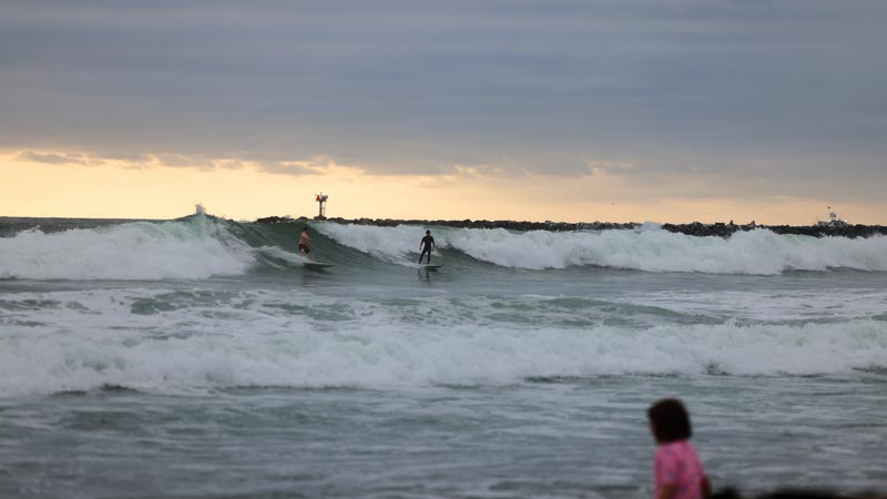 surfer riding wave in ocean beach ca