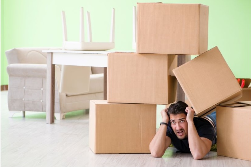 man under a pile of moving boxes