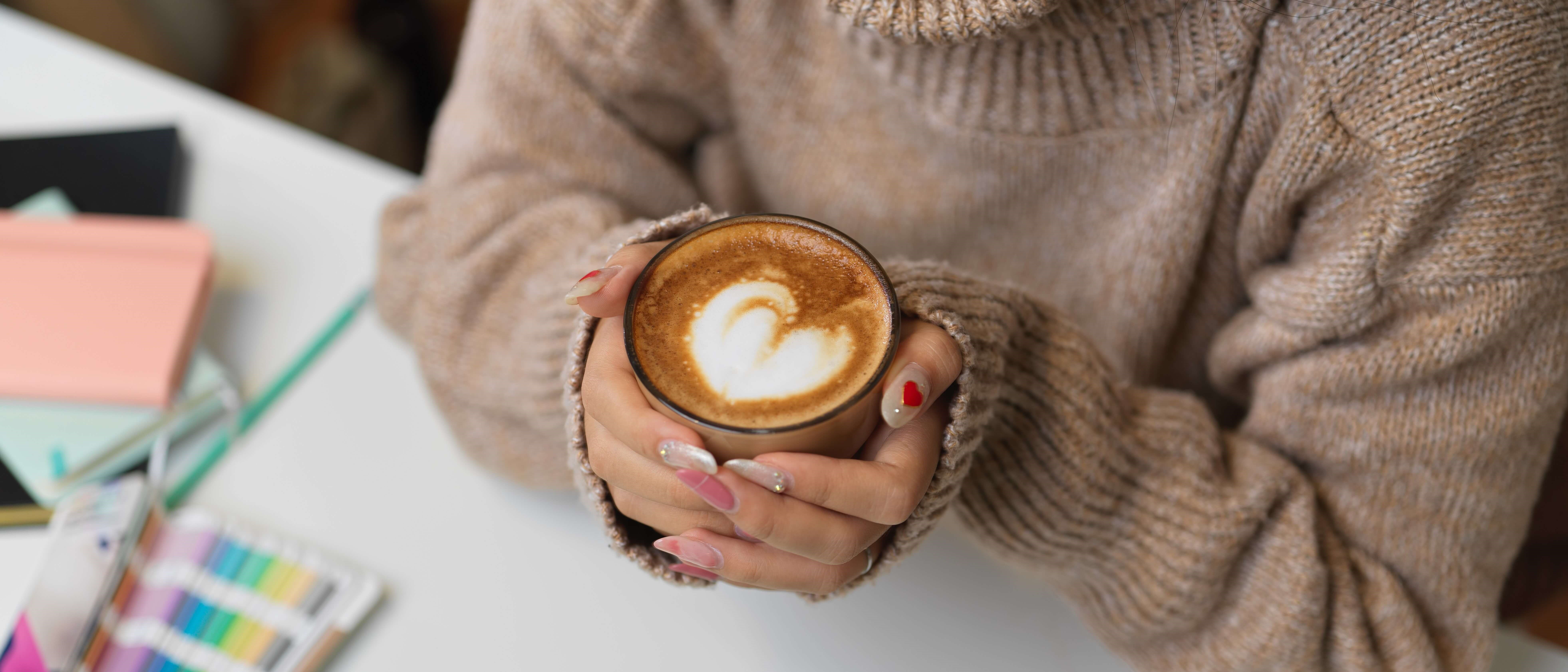 woman in sweater holding a warm coffee