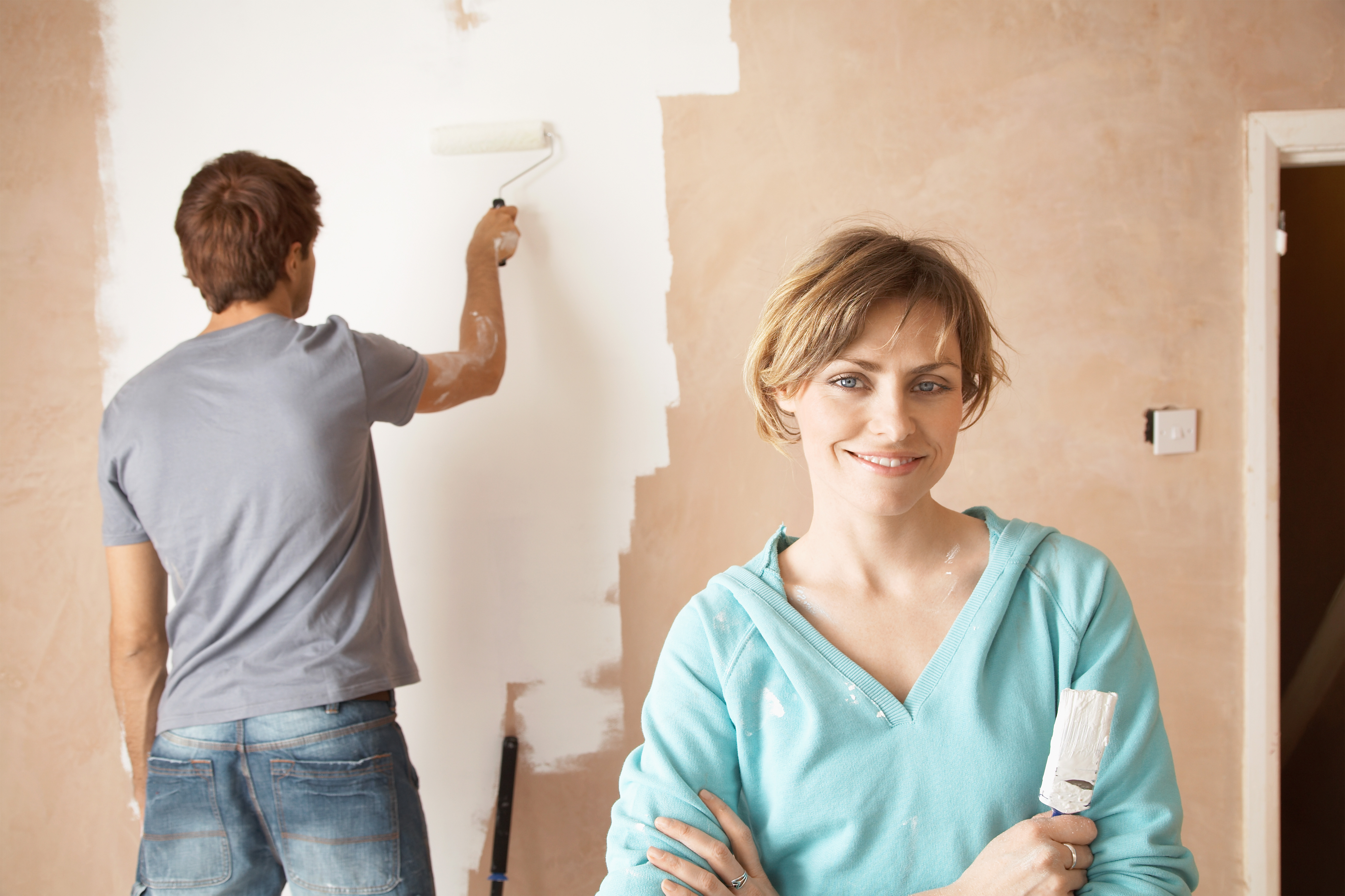 couple painting their own house to get it ready for sale