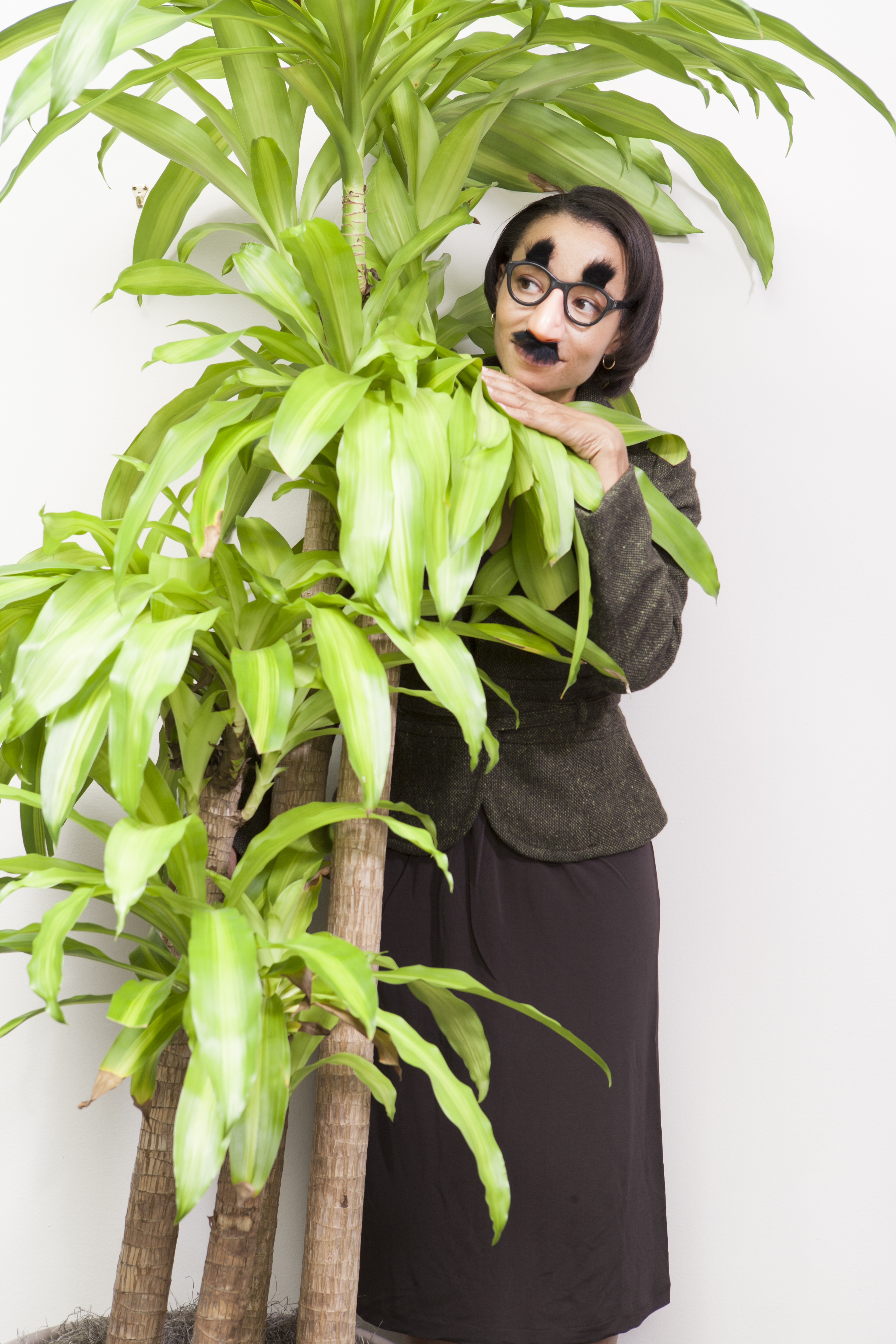 woman hiding behind plant