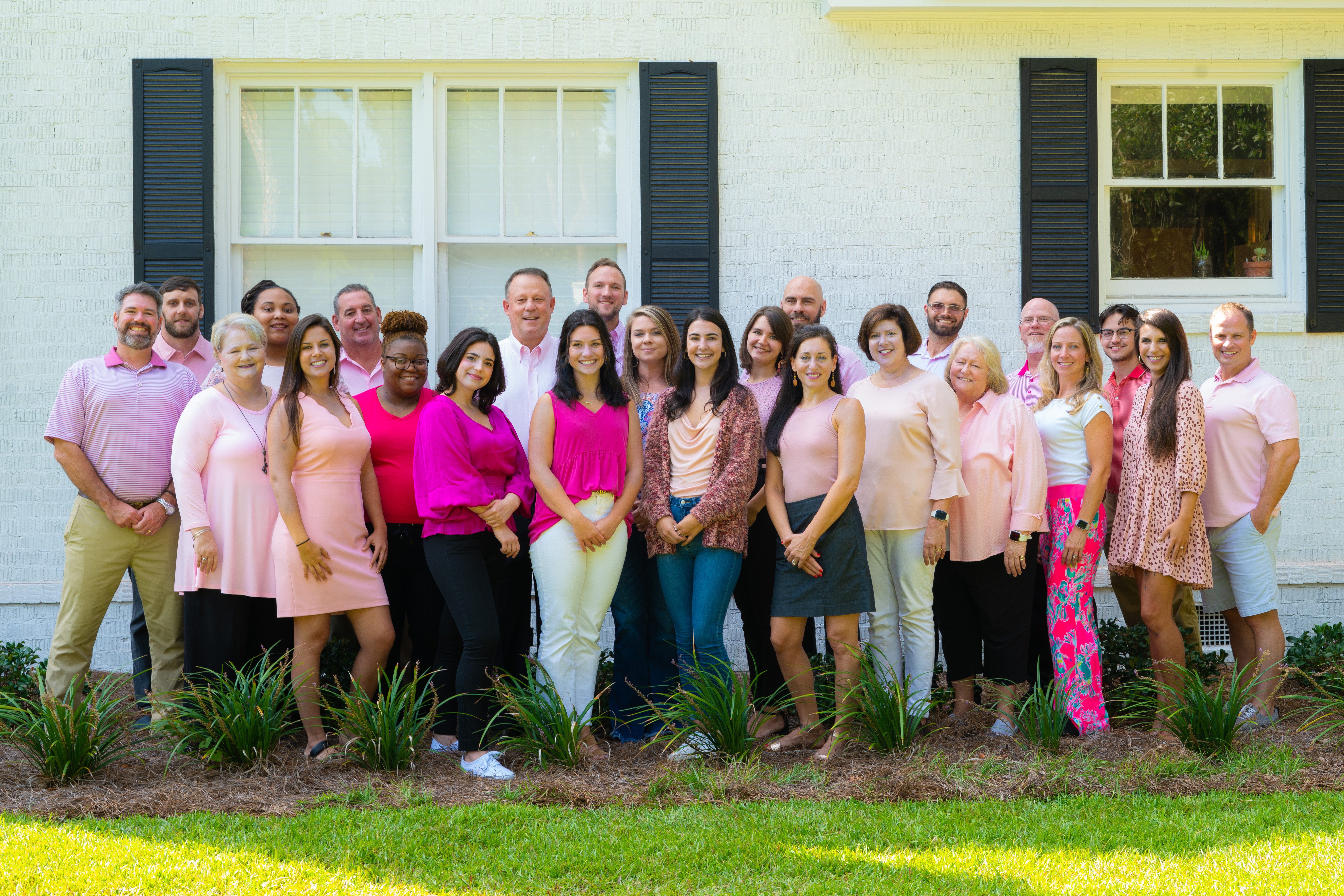 Joe Manausa Company in Pink for Breast Cancer Awareness in front of the Joe Manausa office