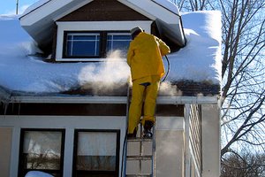 Professional deicing an ice dam.