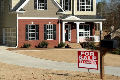 A home in Atlanta, GA with a for sale by owner sign in the front yard.