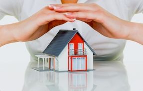 A woman's hands over a home symbolizing the protection available from Metro Brokers insurance.