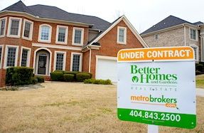 Beautiful two story brick home with BHGRE Under Contract sign in the front yard.