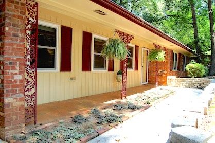 A ranch style home with a walkway to the front door & covered porch.