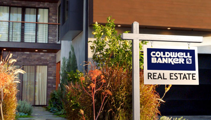 Front of modern home with Coldwell Banker for sale sign - Coldwell Banker Paradise