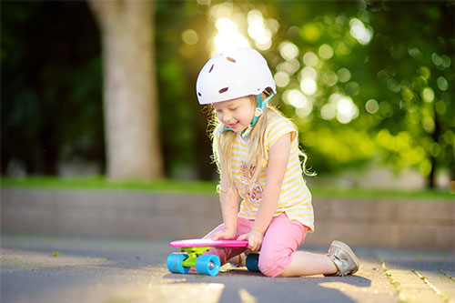 small girl playing with skateboard