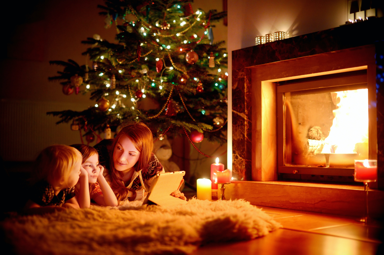 Mom and kids in front of fire during holidays